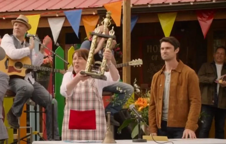 Tara Toney (Nora McLellan) awards a trophy in THE SECRET SAUCE