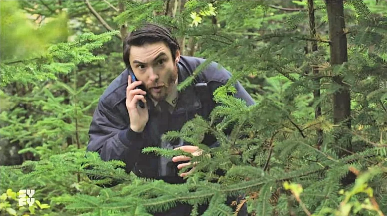 Andrew Tremblett as Officer Drew watching the strange dance behaviour from the bushes - Astrid and Lilly Save the World 104