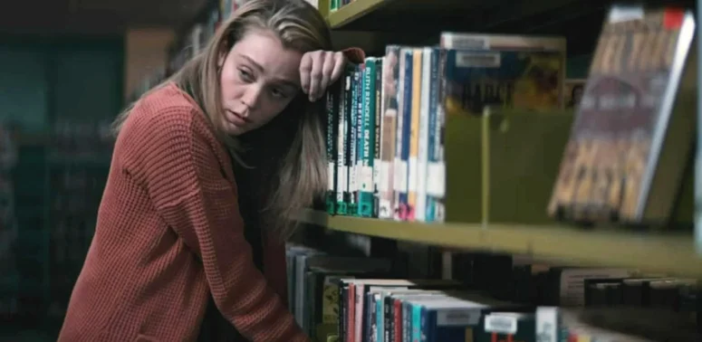Anna (Alanna Bale) at work in the library's mystery section while trying not to feed - Kicking Blood