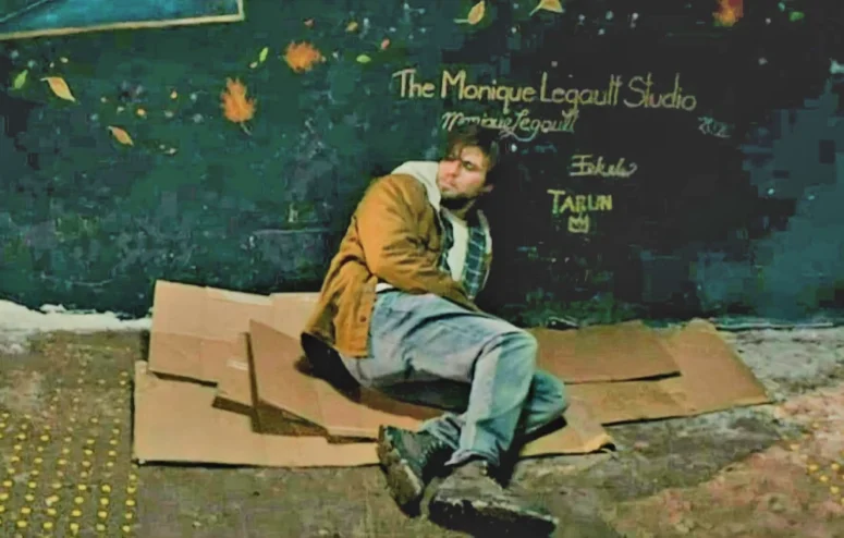 Robbie (Luke Bilyk) in the alley just before meeting Anna. On the wall just above his head is graffiti advertising Sudbury's Monique Legault Studio - Kicking Blood