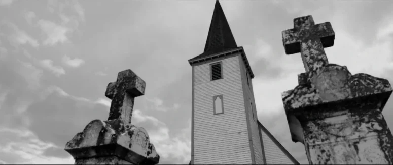 The church steeple seems to be at odds with crosses in the foreground