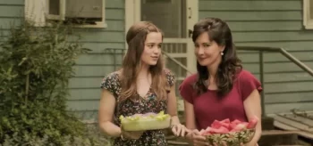 Debbie Glatzel (Sarah Catherine Hook) and her sister Judy (Charlene Amoia) carry flowers in The Conjuring