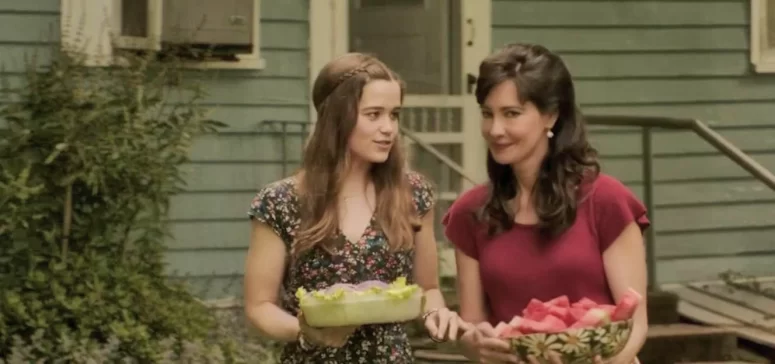 Debbie Glatzel (Sarah Catherine Hook) and her sister Judy (Charlene Amoia) carry flowers in The Conjuring