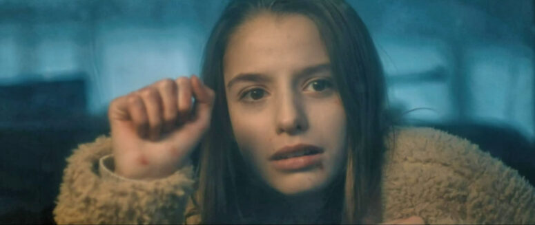 Gloria (Ava Preston) looks sadly through a car's rear window - I'll Take Your Dead