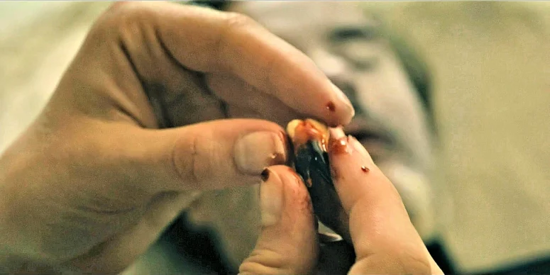 The tooth Sophia removed from the dead pastor, who is visible in the background - From 403