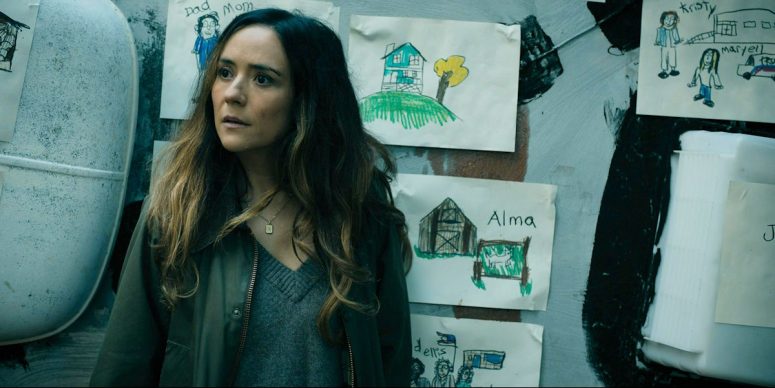 Tabitha standing in front of the RV which has Ethan's drawings posted on its roof - From 408