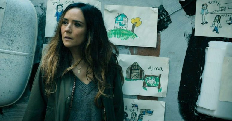 Tabitha standing in front of the RV which has Ethan's drawings posted on its roof - From 408