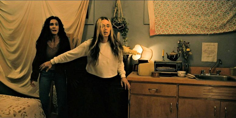 Mari (Kaelen Ohm) tries to shield her patient Fatima (Pegah Ghafoori) from the Smiley Creature - From 410