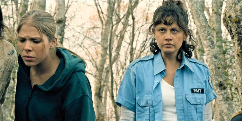 After the bottle tree is uprooted, Acosta (Samantha Brown) peers into the hole it left behind and Kristi (Chloe Van Landschoot) looks concerned. - From 410