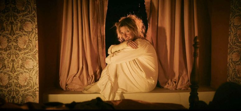 Harriet (Sheila McCarthy) sits smiling on a windowsill - The Voices of Our Mother
